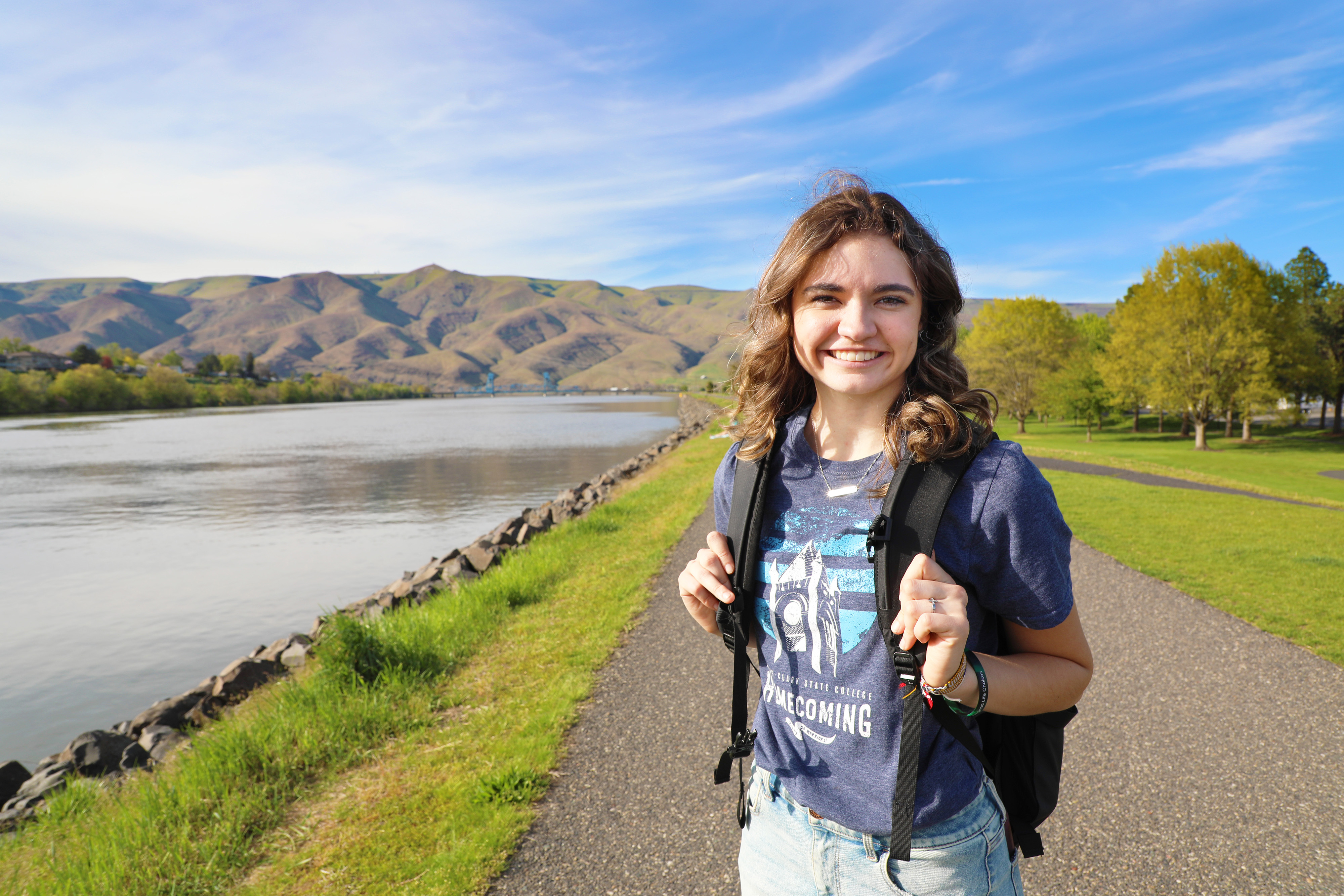 Female student outside with Snake River and hills in background