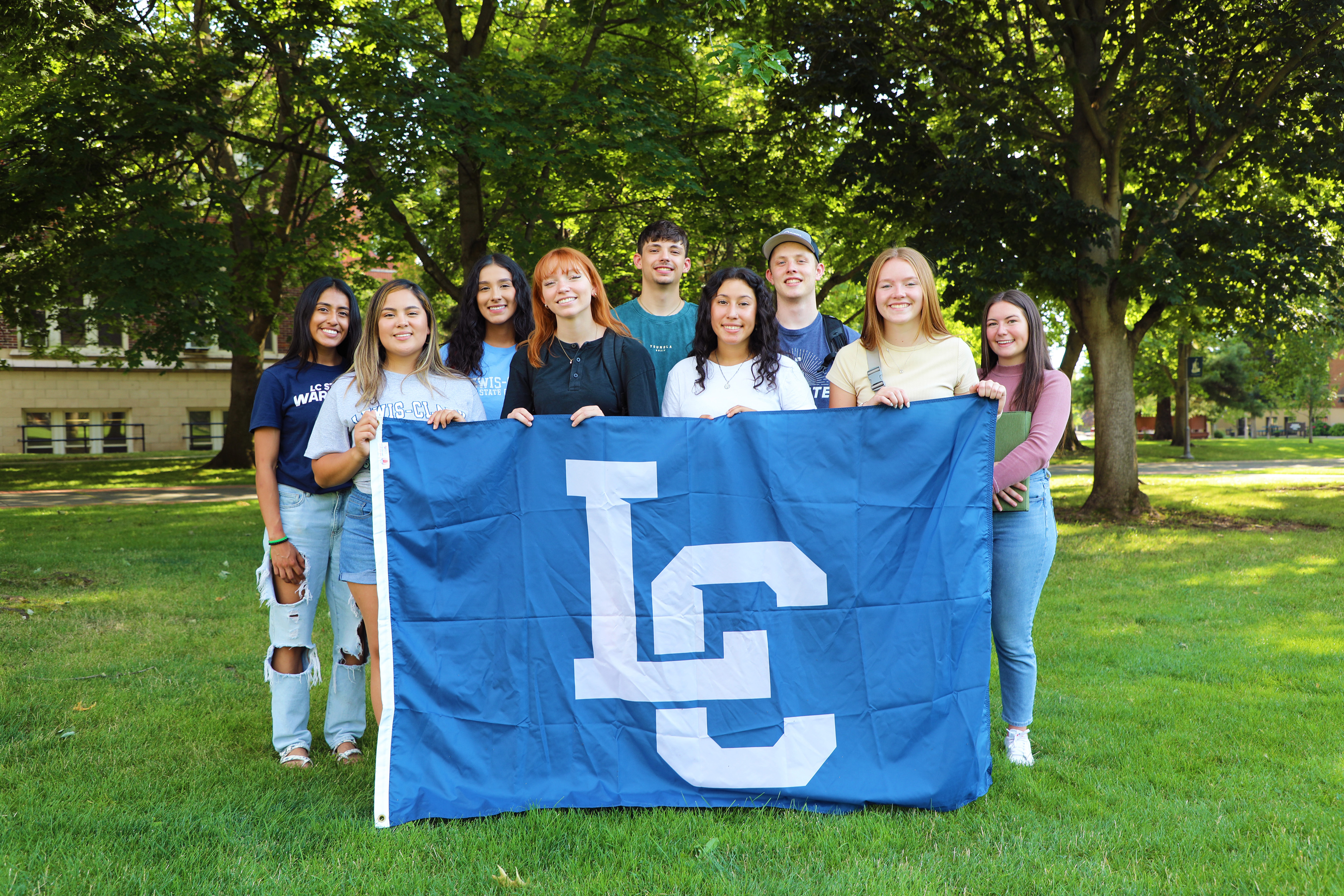 A group of LC State Students holding the interlocking LC blue flag