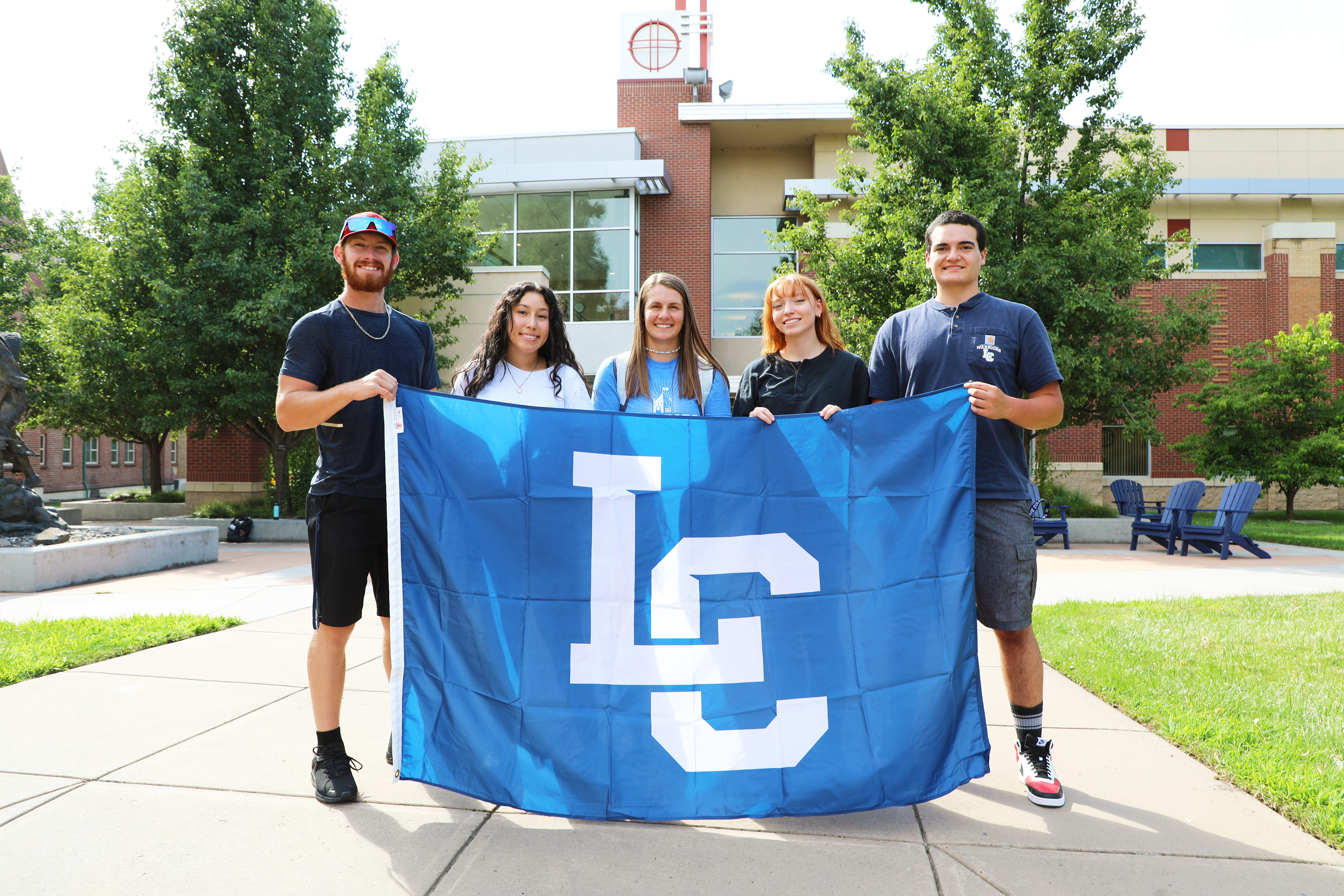 Group of LC State students posing with LC State flag
