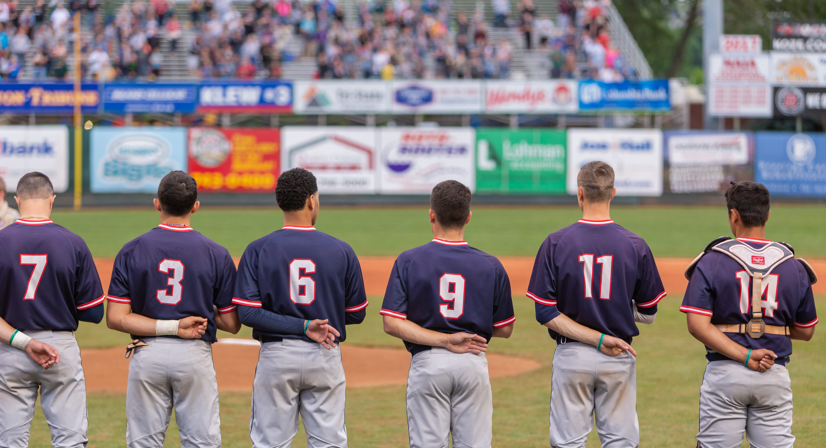LC baseball players standing for the national anthem