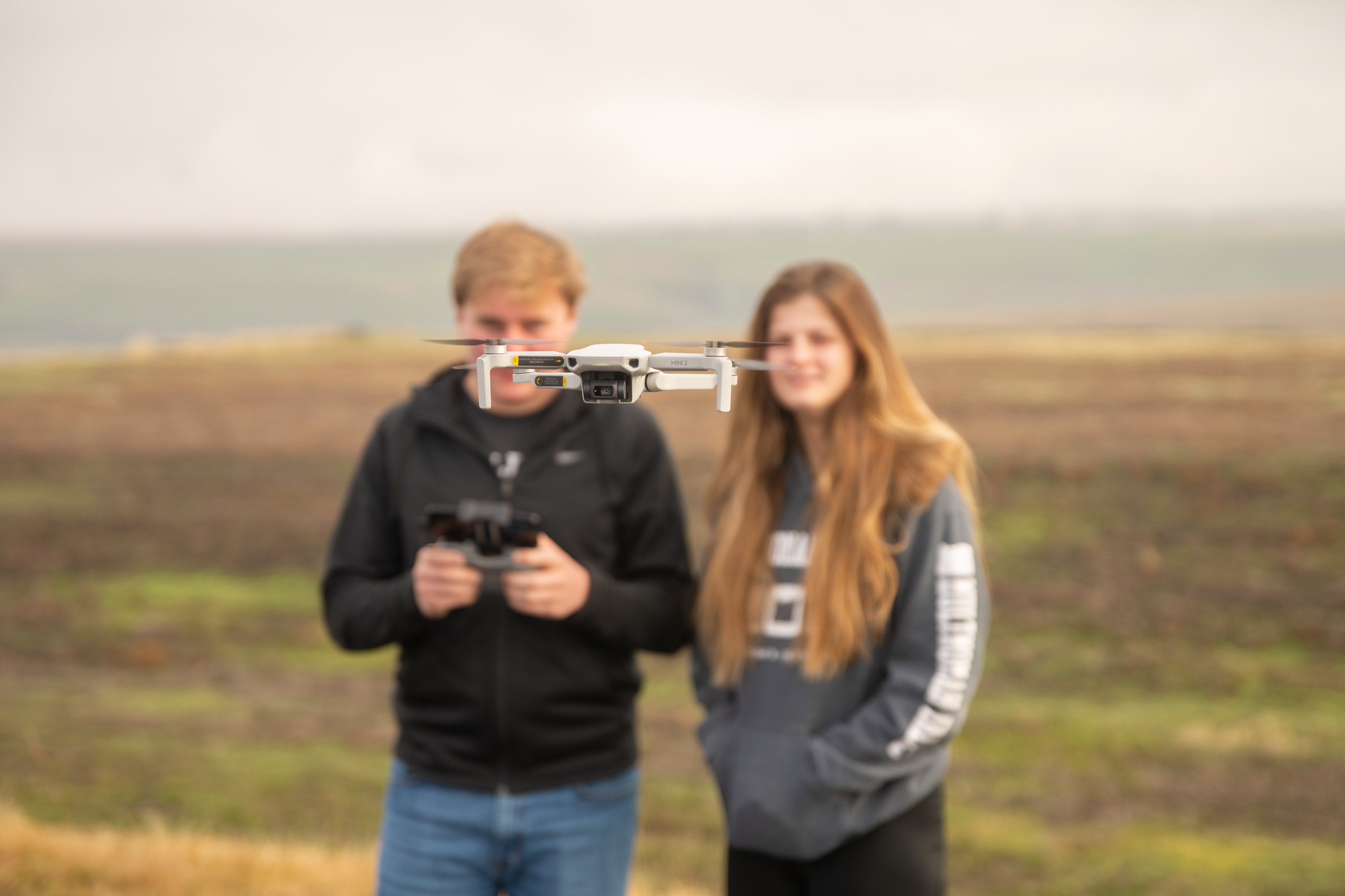 Two People Flying A Drone