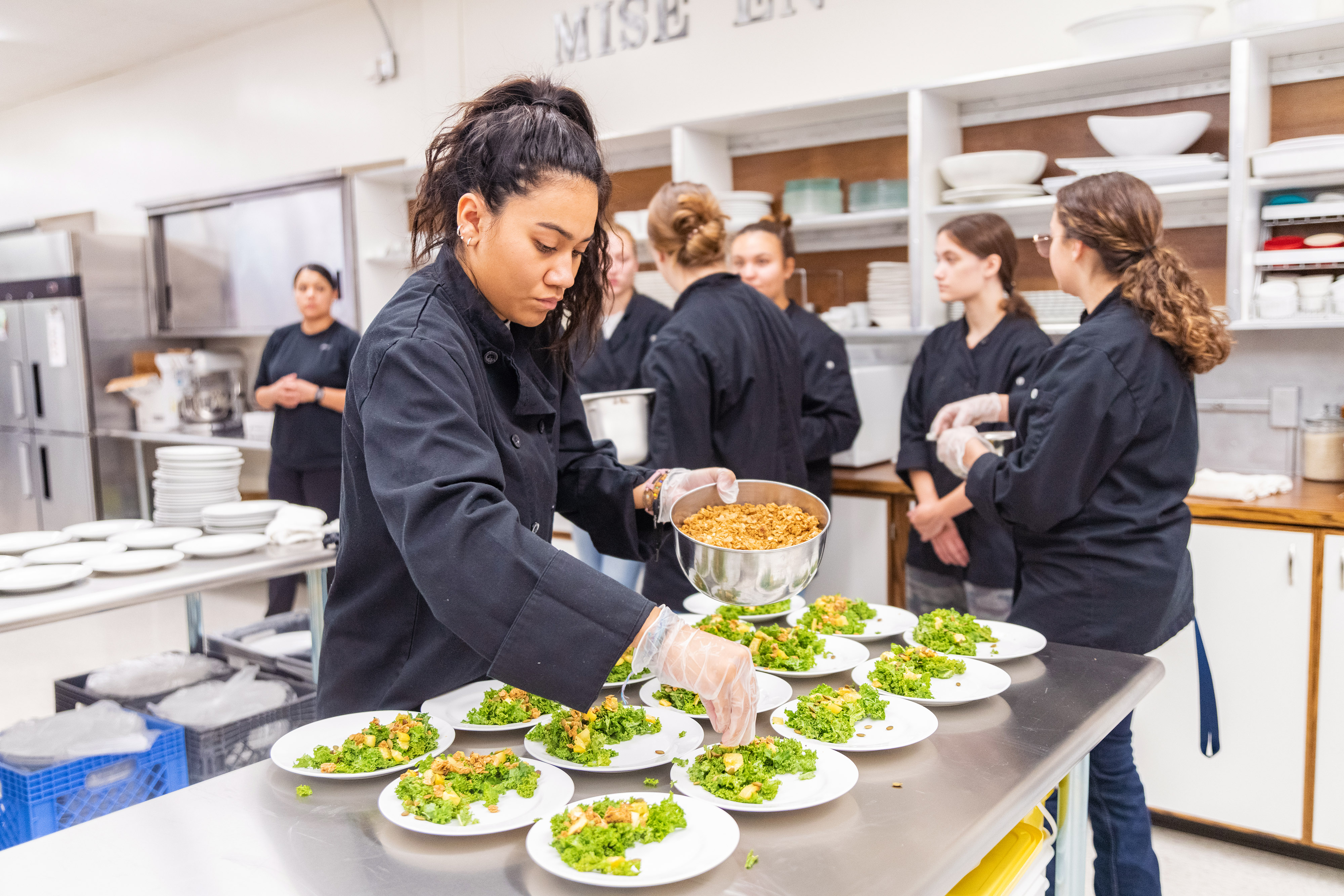 Hospitality management student preparing salads