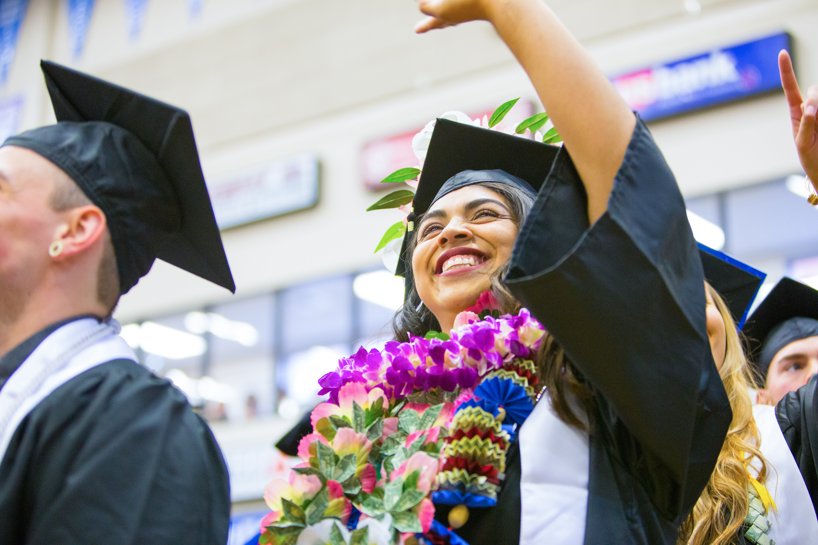 Graduate waving to their family at Commencement. 