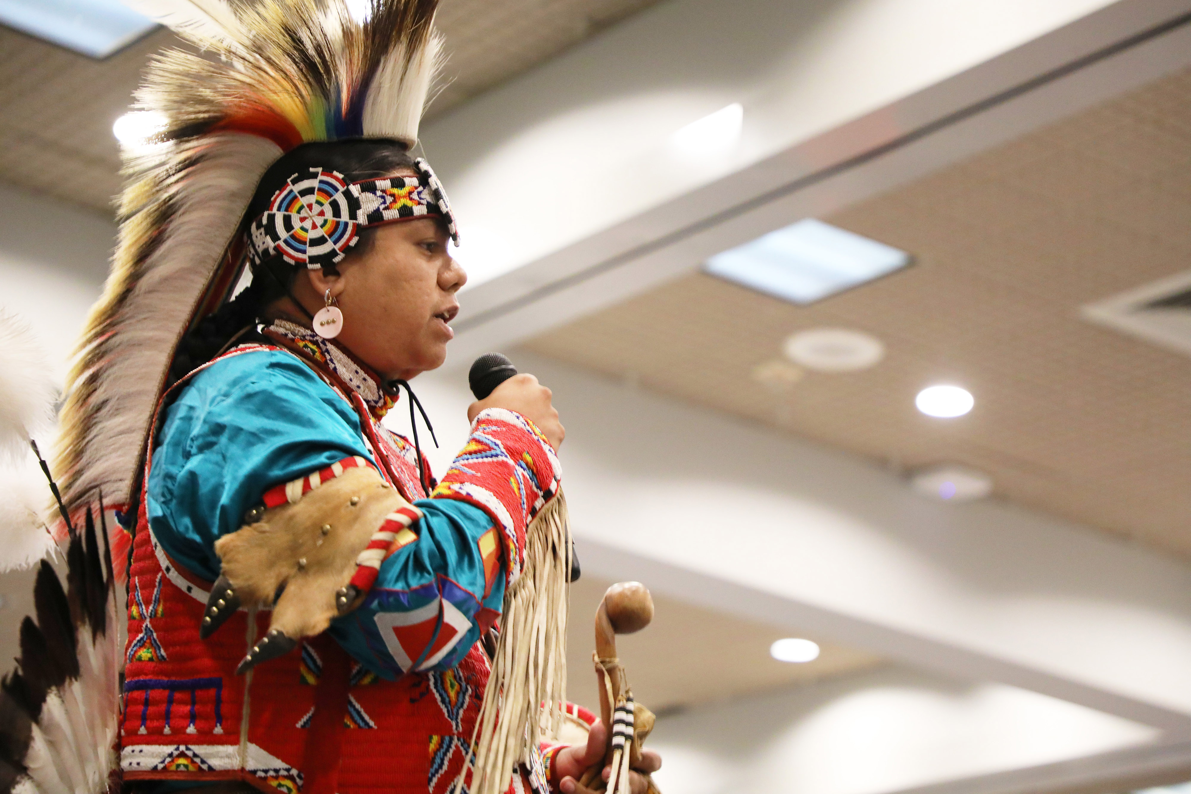 Person in traditional Native American clothing giving presentation