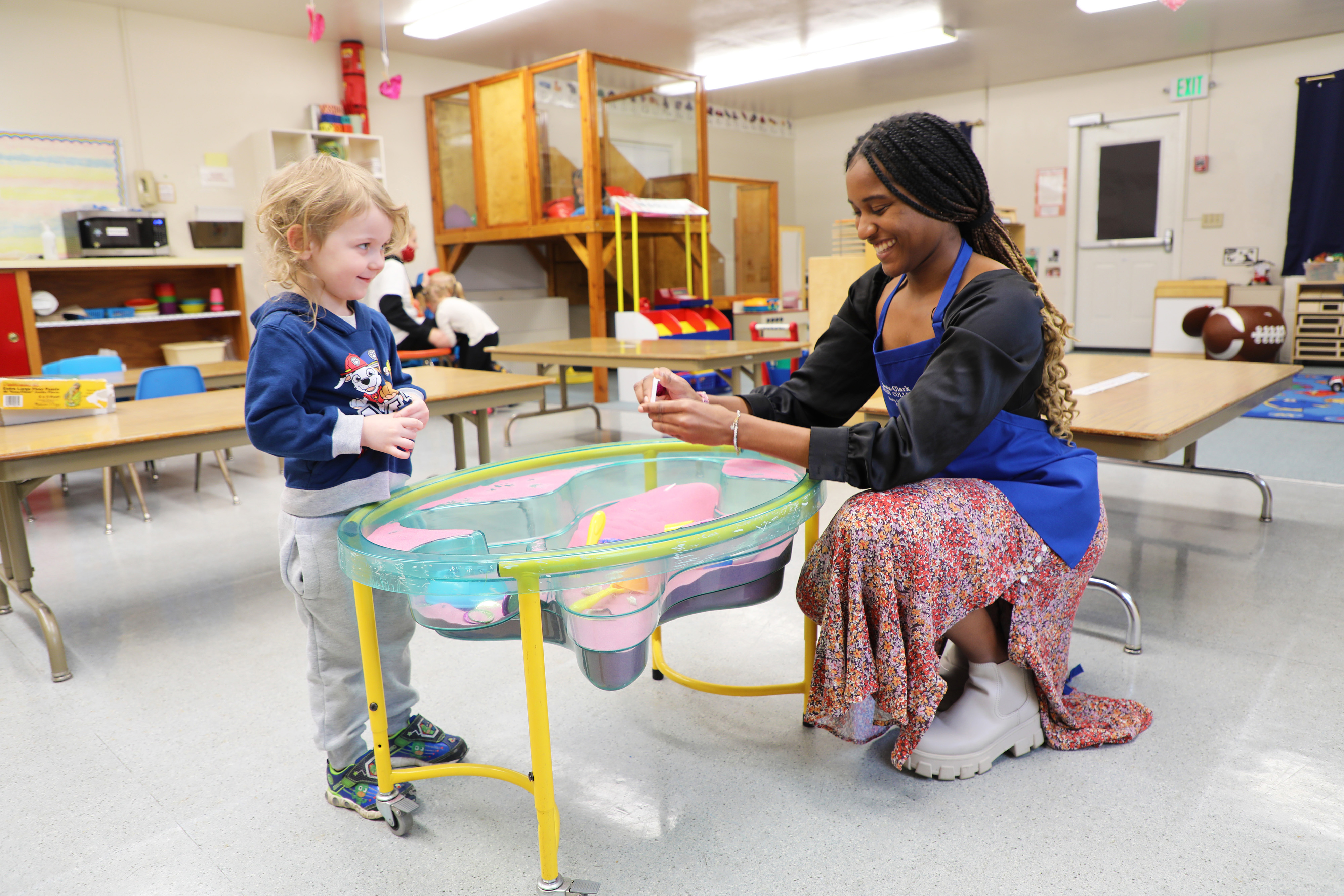 Student with a child in a classroom
