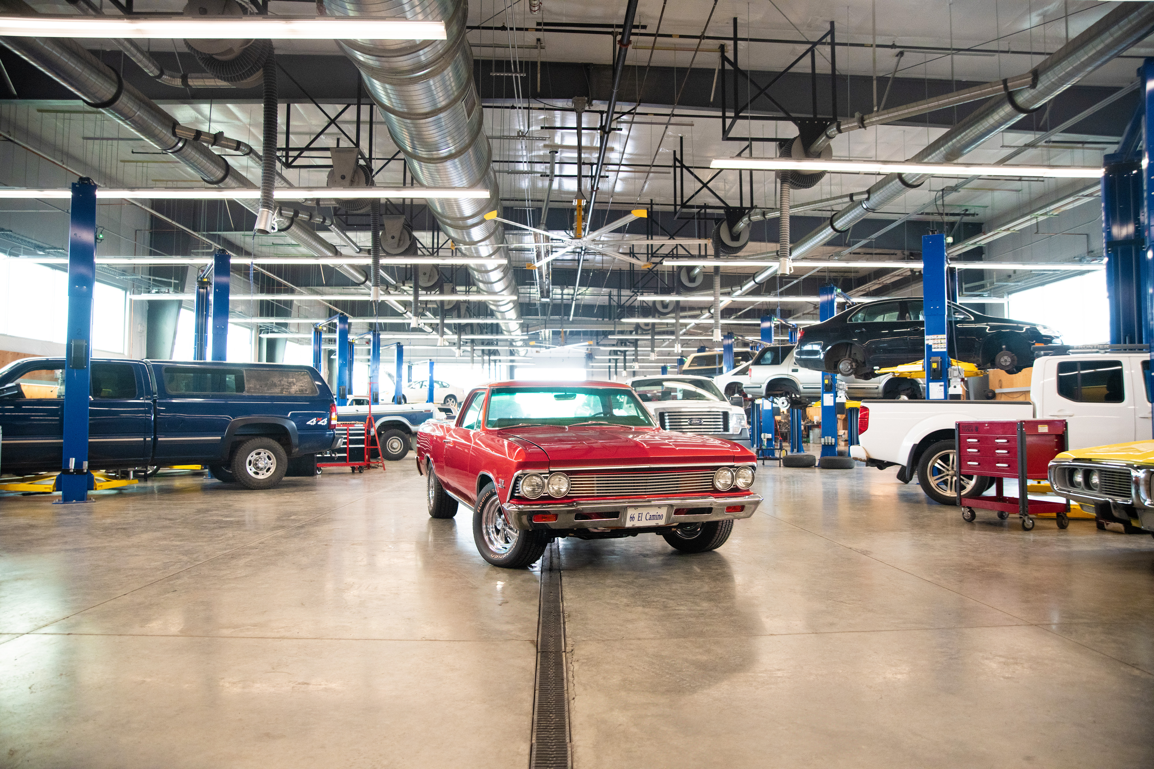 Red car staged in middle of automotive shop