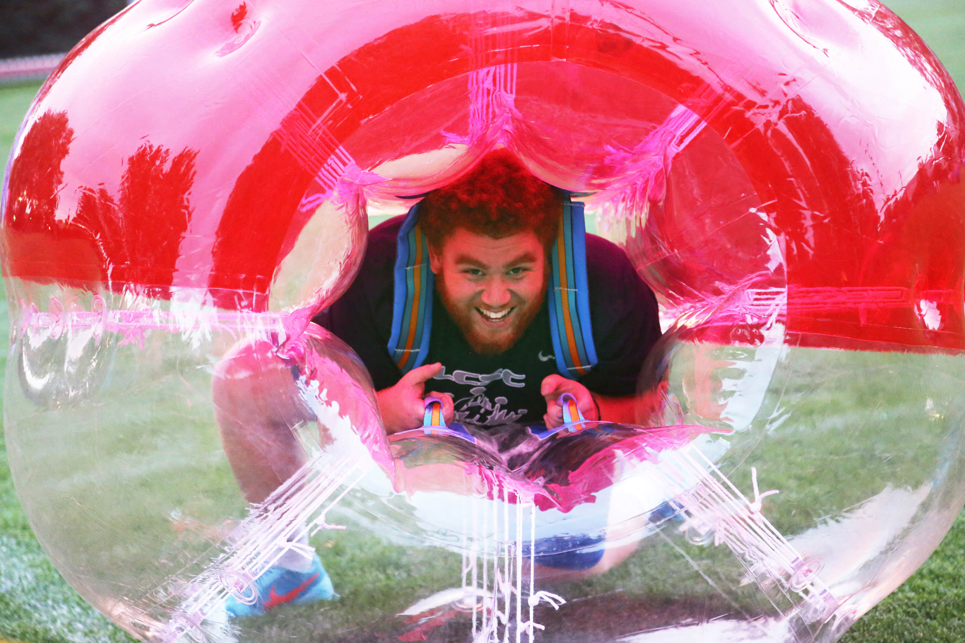 Male student inside a bubble ball smiling