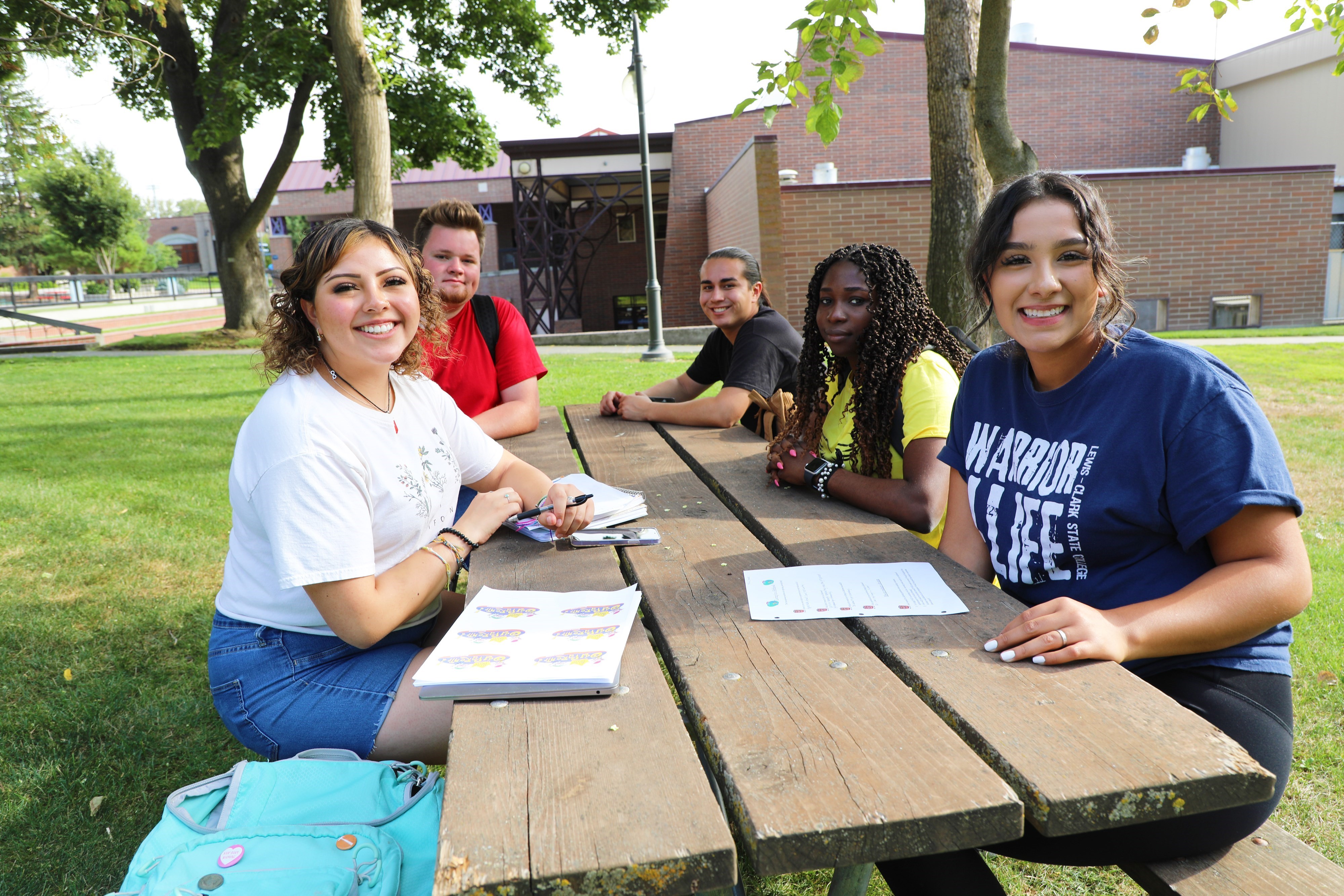Students sitting in the center of campus.