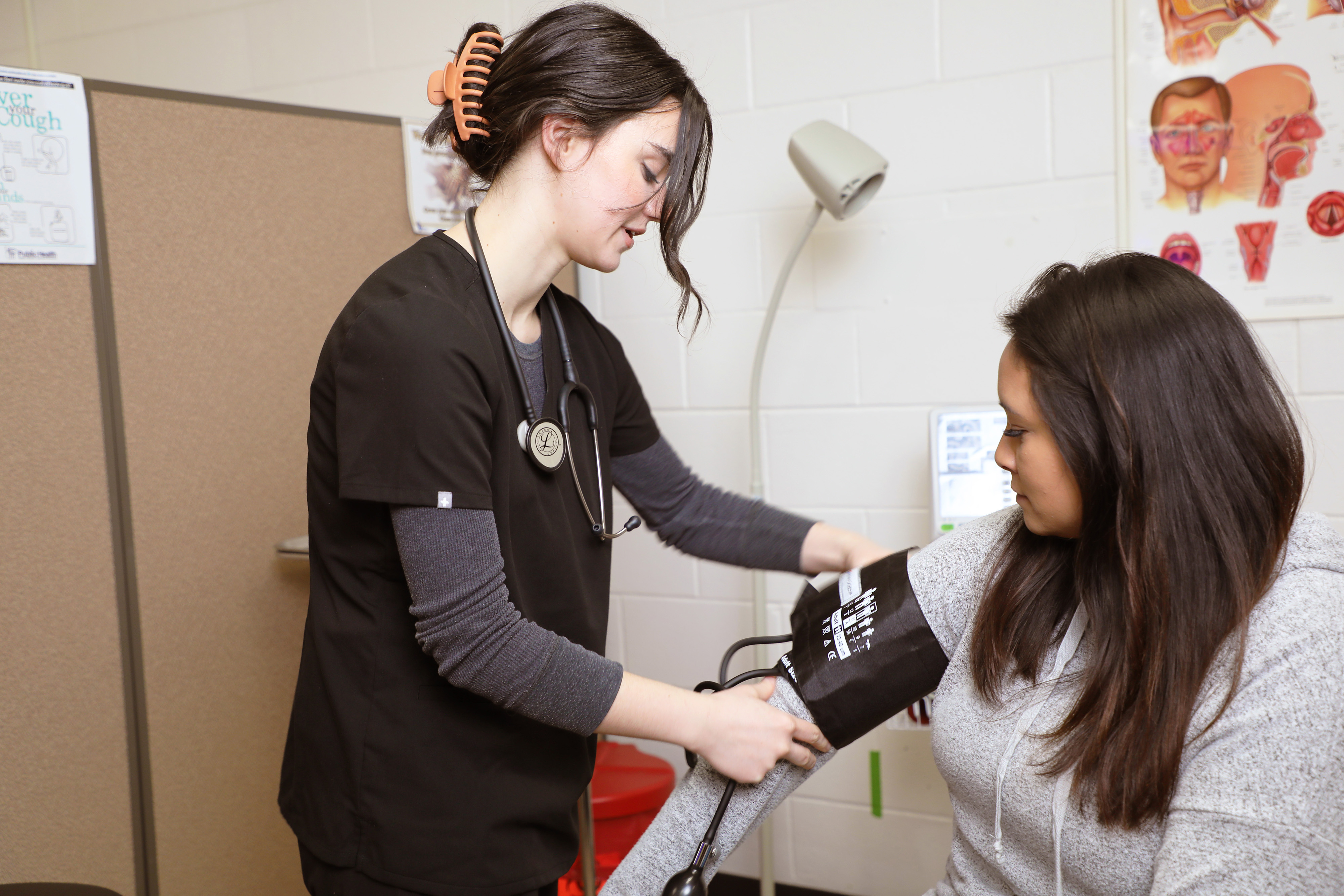 Student taking blood pressure of another student