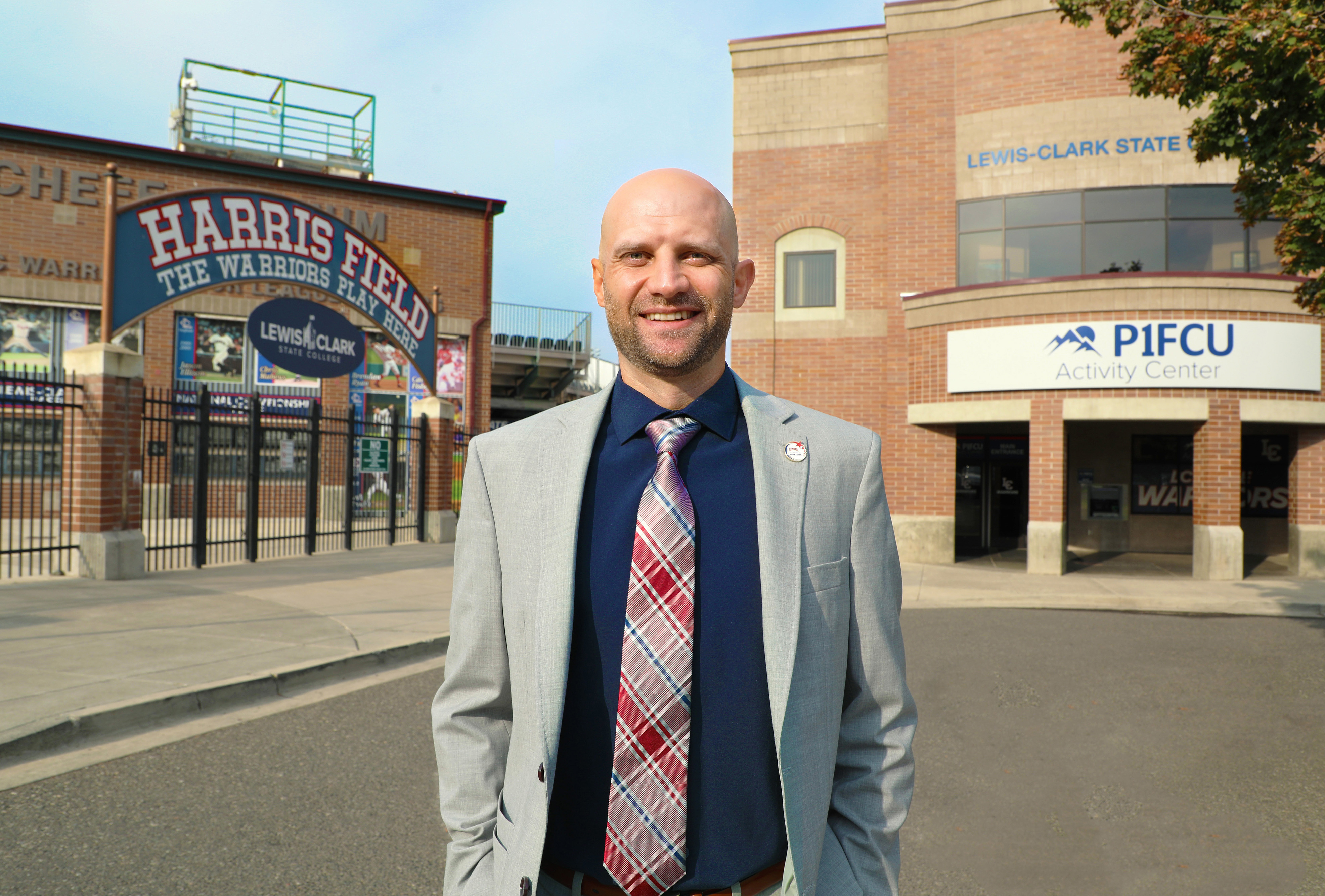 Jim Klemann stands in front of P1FCU Activity Center and Harris Field