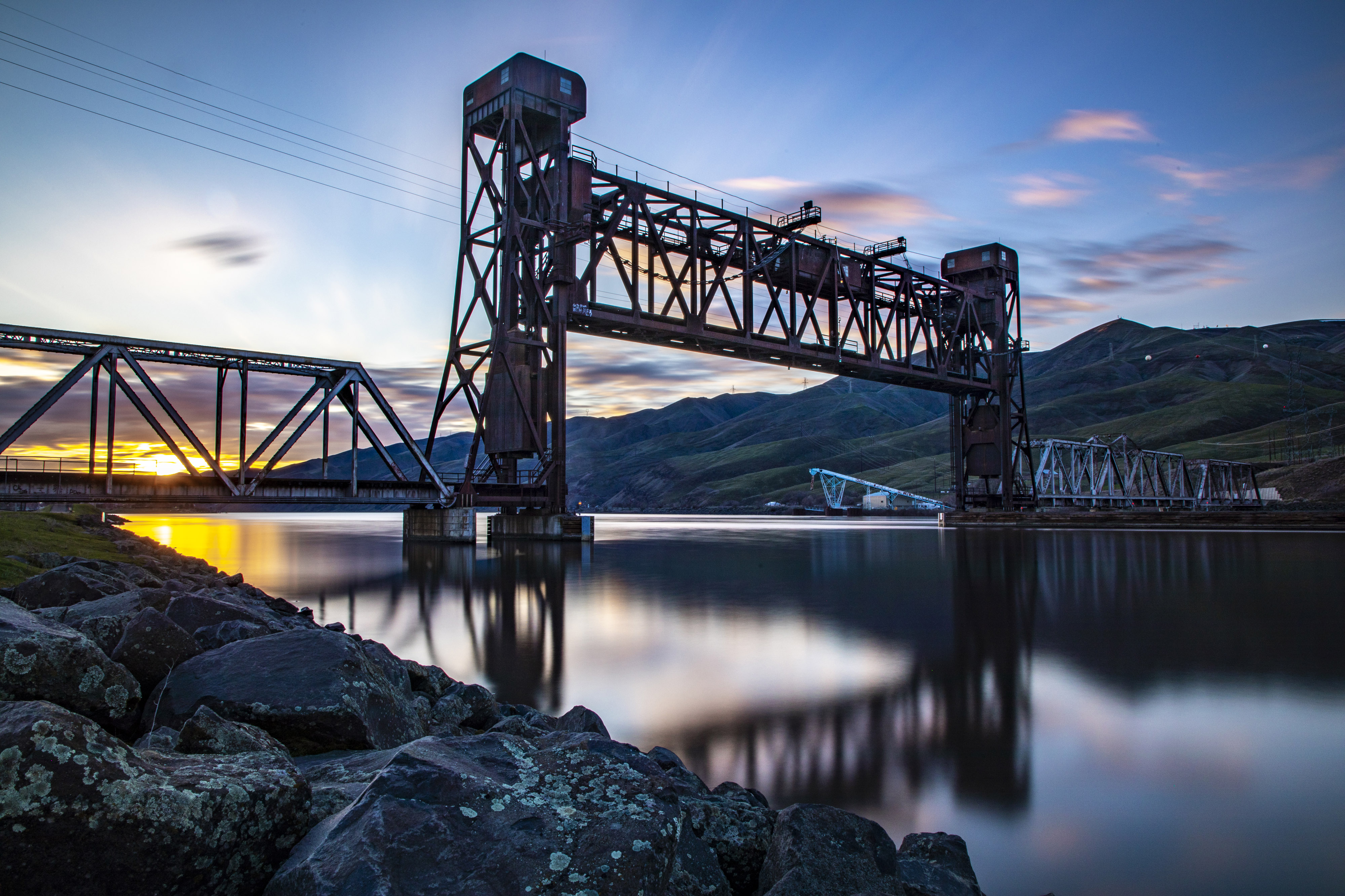 Sunset photo of Clearwater River and Bridge with mountains in background