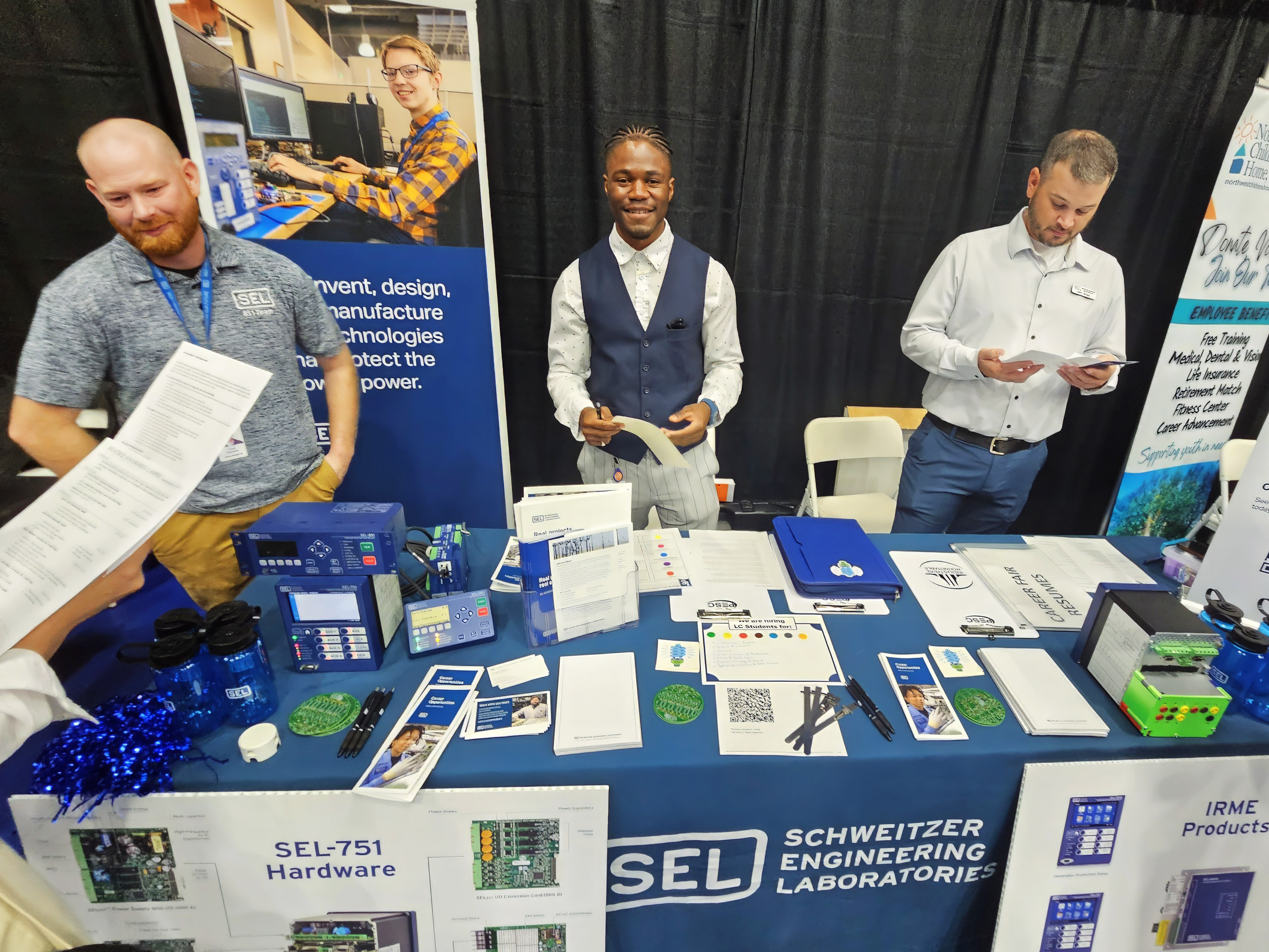 Marc Batete Posed with two others at Schweitzer Engineering Laboratories' Career Fair Table 