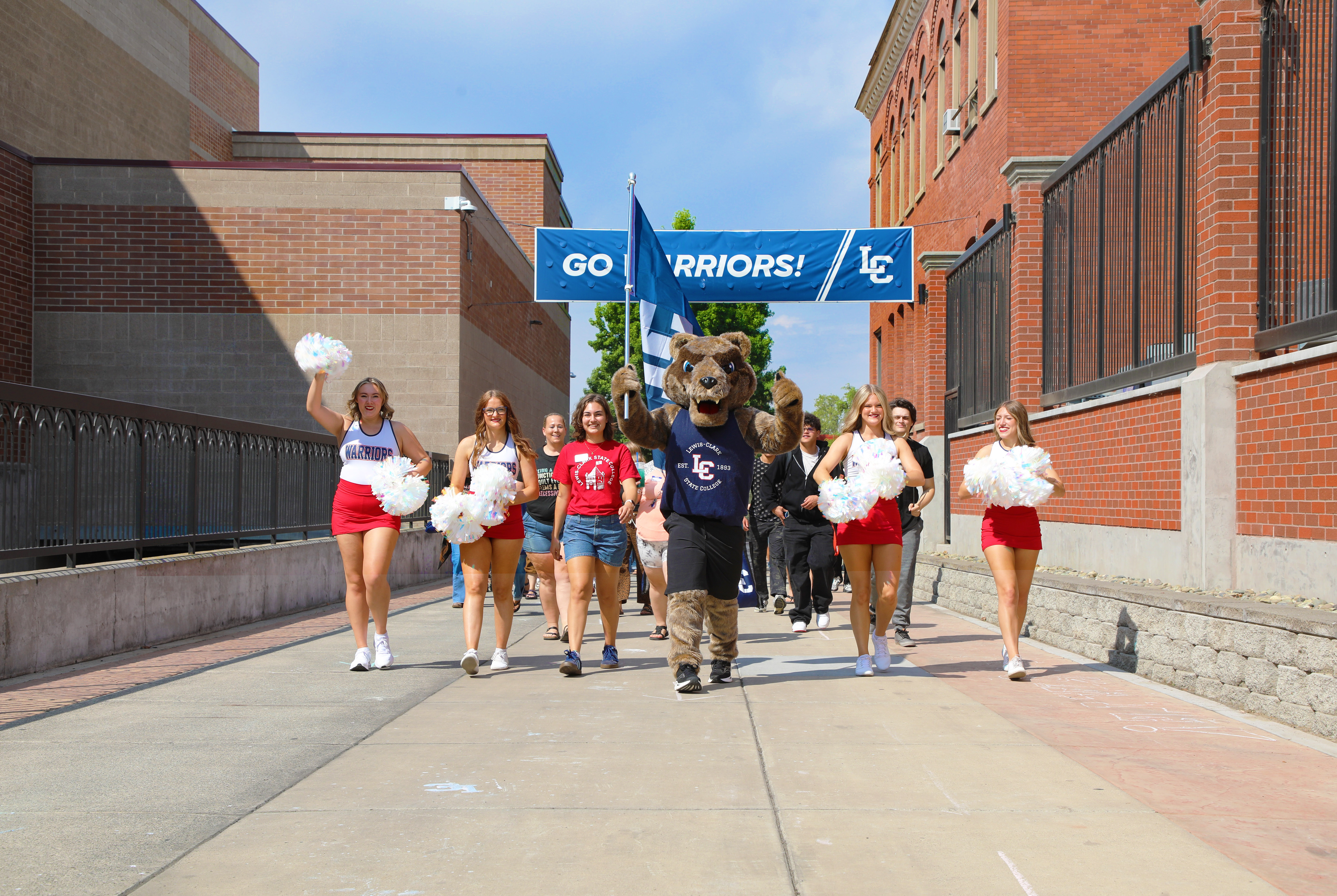 The Warrior Wolverine leads the serpentine with LC State cheerleaders and ASLCSC President Rayne Martinez