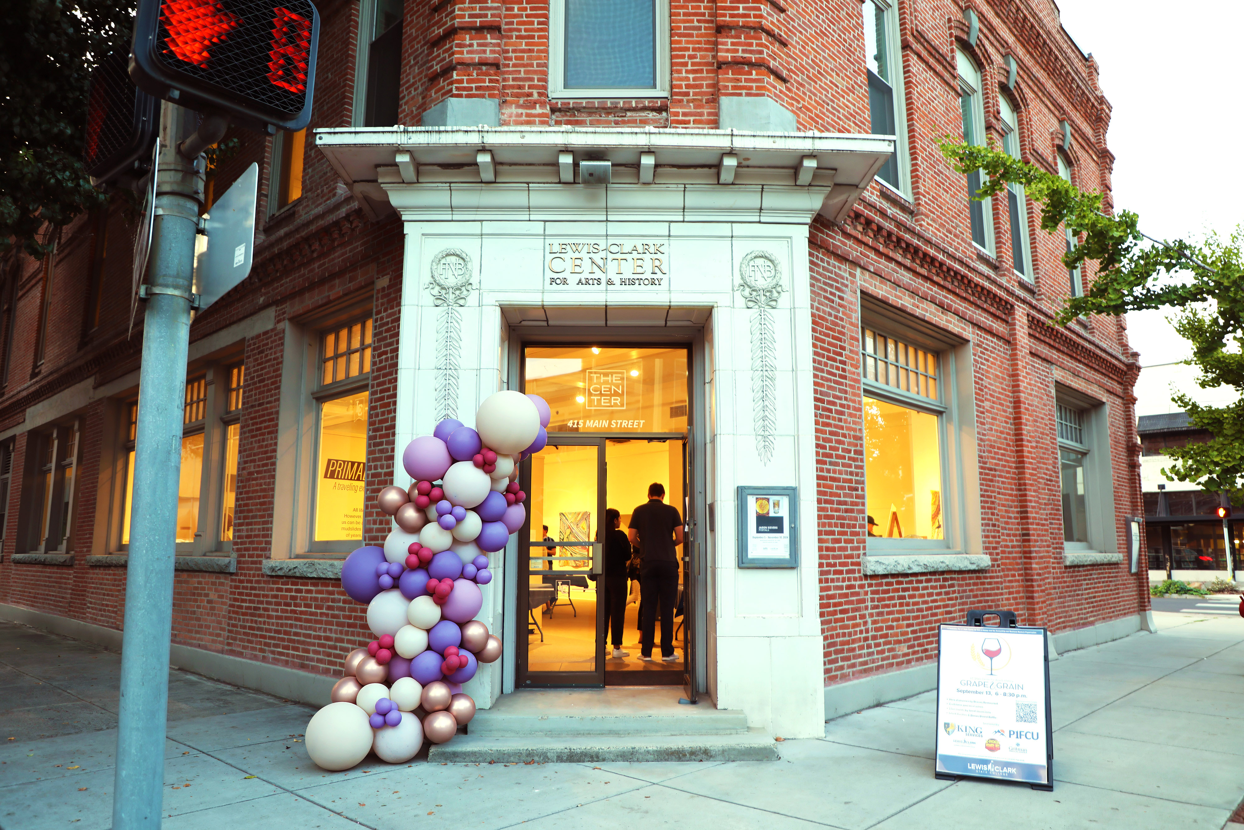 Outside Entrance of Center of Arts & History decorated with purple, pink, and white balloons