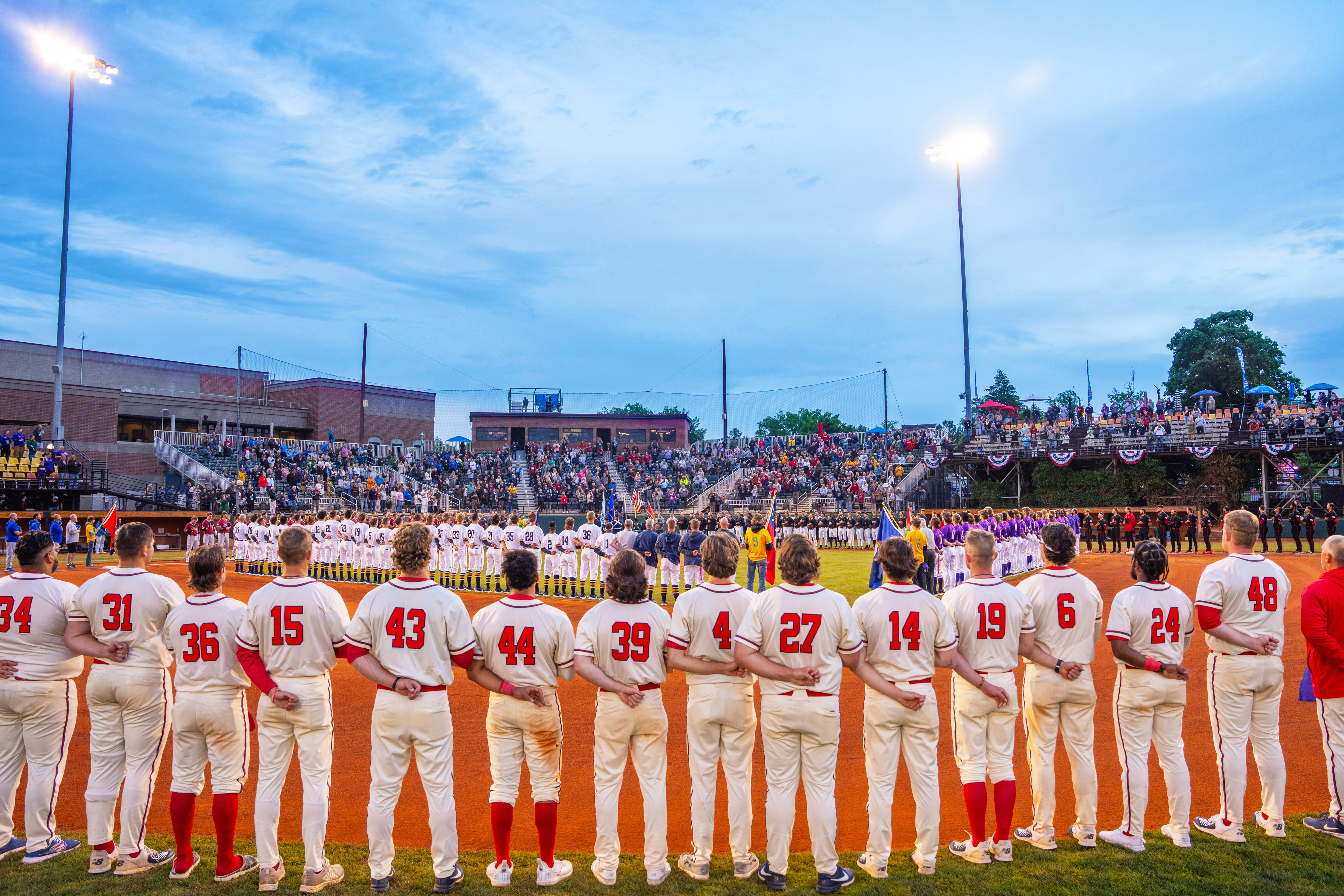 Baseball players lined up throughout baseball diamond